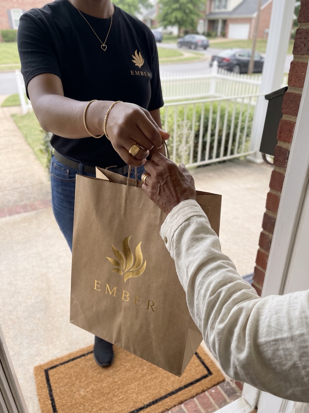 Ember courier handing a sealed Ember bag to a customer at their front door