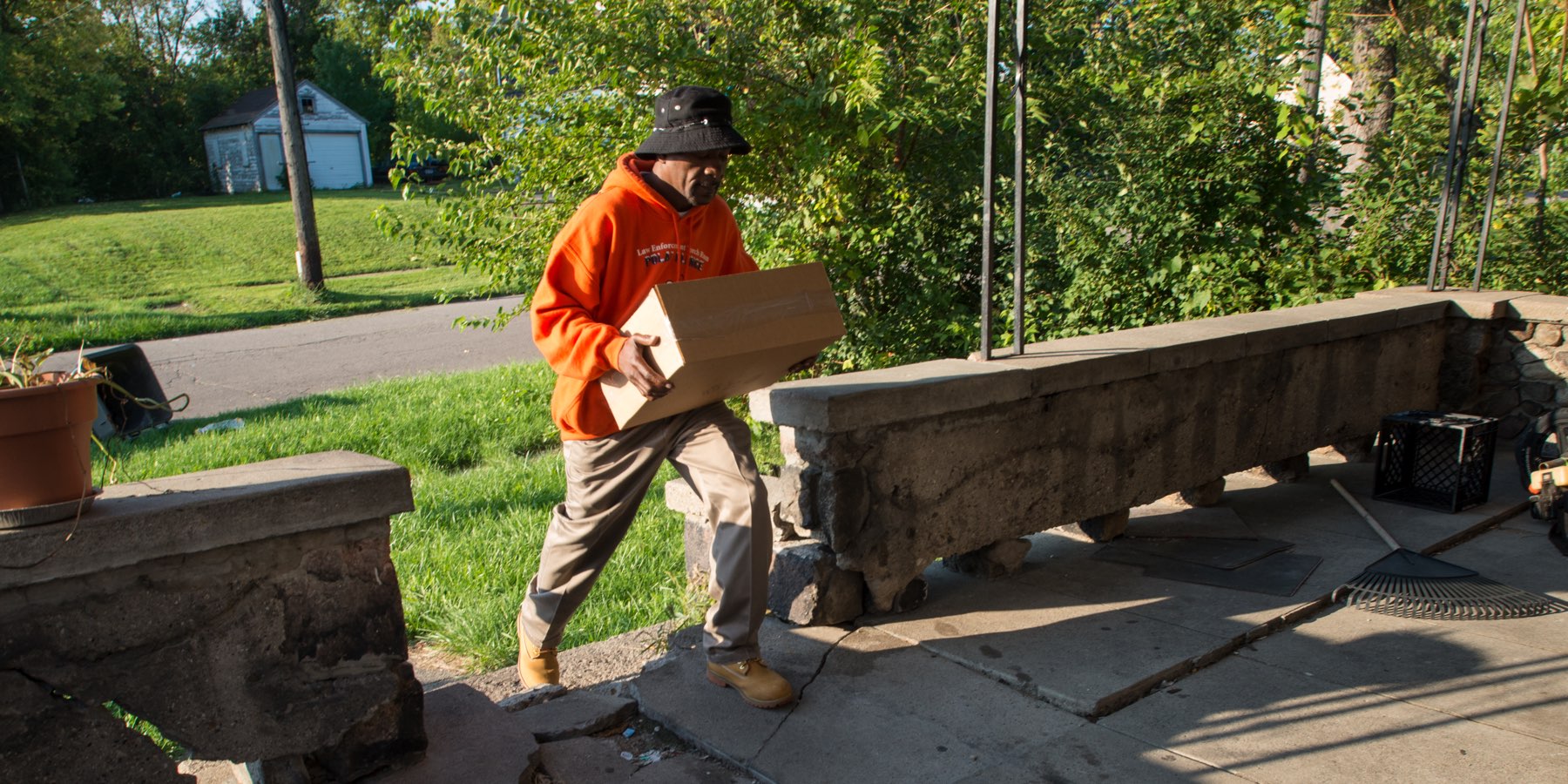 Courier crossing a front yard with a sealed box
